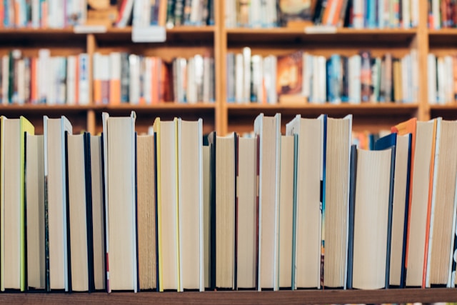 Photo de livres avec en arrière plan des étagères de livres